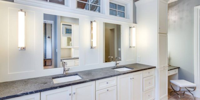 light bathroom with double vanity and windows